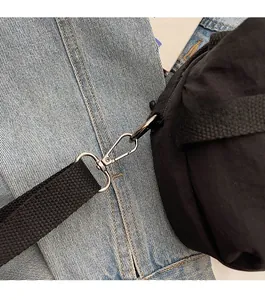 Detailed macro shot of high-quality silver metallic hardware and black woven shoulder strap