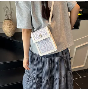Detailed embroidery on the front flap of this elegant cross-body bag with floral buckle