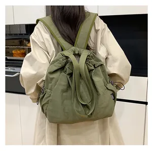 Detail van legergroene nylon emmertas met trekkoord, textuur en LUX-zijlabel op de tas
