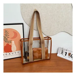 Macro detail of transparent PVC tote with striped canvas strap and leather trim
