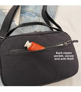 Detail of the back security zipper pocket on the black nylon crossbody shoulder bag