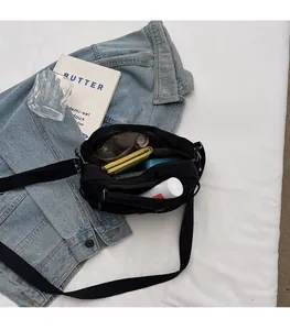 Internal view of the black nylon crossbody bag showing spacious capacity and pockets