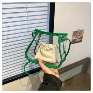 Detailed shot of a transparent PVC crossbody bag with green trim and canvas insert