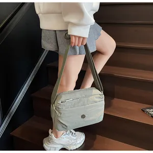 Detail einer Nylon-Umhängetasche mit Reißverschluss und verstellbarem Gurt auf der Treppe