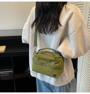 Detailed back view of model wearing a green nylon crossbody bag with wide strap