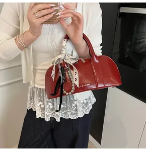 Detalle del bolso Boston rojo brillante con cinta de encaje y cadena de perlas moda