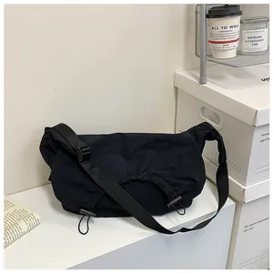 Dettaglio borsa a tracolla nera pieghettata con tracolla regolabile e coulisse decorative