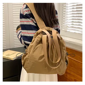 Achteraanzicht van kaki nylon tas met trekkoord gedragen door model in huiselijke sfeer