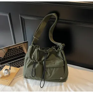 Detail view of army green nylon crossbody bag with drawstring pockets and adjustable strap