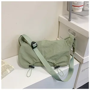 Dettaglio borsa hobo a pieghe in nylon verde chiaro con fibbia regolabile e coulisse laterale