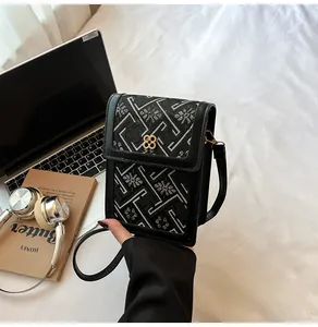 Detail of Chinese style embroidery crossbody bag with metallic floral clasp and leather strap