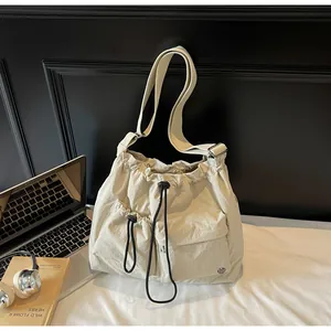 Detailed view of beige nylon crossbody bag with pleated texture and functional pockets