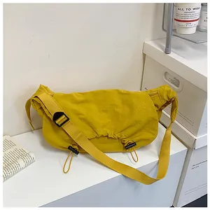 Dettaglio borsa a tracolla giallo zenzero con coulisse e tessuto testurizzato