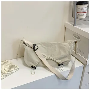 Dettaglio della borsa a tracolla in tela bianco crema con tracolla regolabile e patta