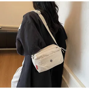 Detailansicht der cremefarbenen Nylontasche mit verstellbarem Gurt und Reißverschlüssen