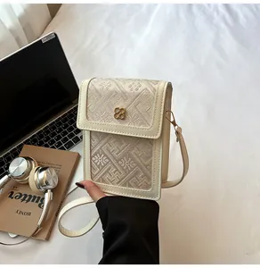 Detailed close-up of intricate floral embroidery and golden flower clasp on the bag