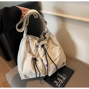 Detail view of large nylon crossbody bag with drawstring pockets and wide shoulder strap