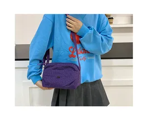 Détail du sac bandoulière en toile à carreaux mauves avec bouton-pression et bandoulière