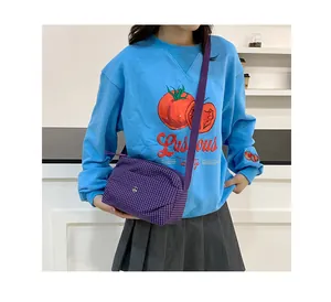 Détail du sac à bandoulière en toile à carreaux violets avec boucle en métal fine