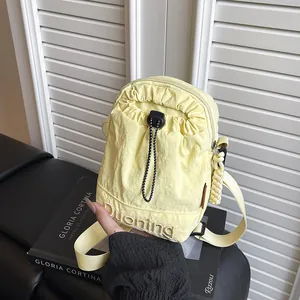 Japanese style light yellow nylon crossbody bag with drawstring pocket and adjustable strap