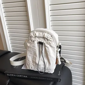 Cream nylon crossbody bag with drawstring detail and sporty white strap accents