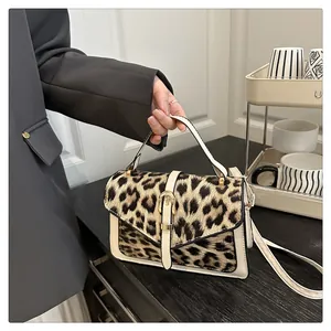 Detail of leopard print handbag showing golden buckle and premium faux leather trim