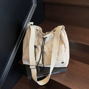 Minimalist beige nylon crossbody bag with pleated texture and dual front pockets