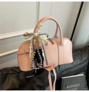 Bolso bandolera rosa minimalista con encaje y detalle de lazo blanco y negro