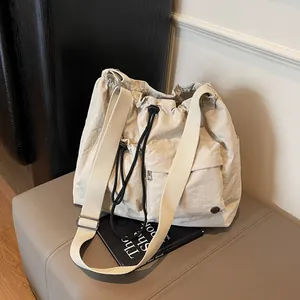 Minimalist beige nylon crossbody bag with drawstring design and spacious front pocket