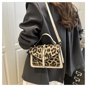 Rear view of a model wearing the leopard print patchwork crossbody bag with a white coat
