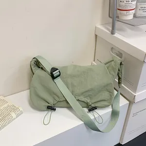 Borsa a tracolla plissettata in nylon verde salvia con coulisse nera regolabile