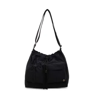 Minimalist black nylon crossbody bag with drawstring closure and large front utility pockets