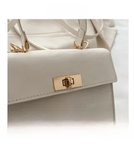 Gros plan détaillé d'un fermoir rotatif en métal doré sur un sac beige minimaliste