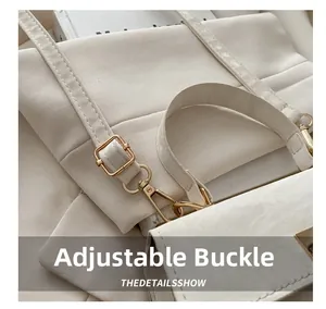 Détail de la boucle réglable dorée et du crochet rotatif sur le sac à main blanc crème