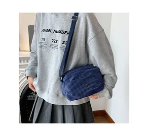 Détail du sac bandoulière en toile à carreaux bleu foncé avec bandoulière réglable
