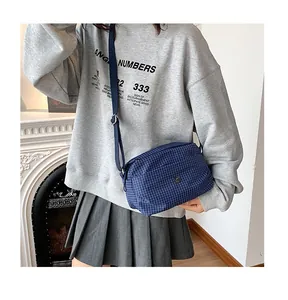 Détail du sac à bandoulière en toile à carreaux bleu marine avec sangle réglable