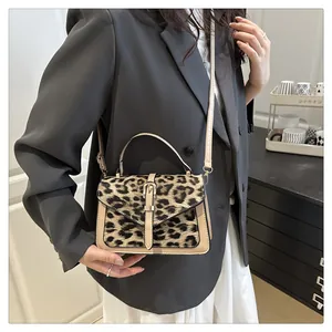 Detail of trendy leopard print handbag with PU leather straps and metallic buckle accent