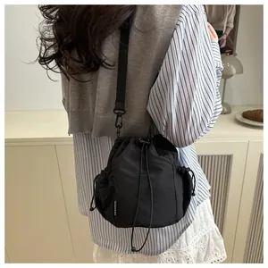 Nahaufnahme der schwarzen Tunnelzug-Beuteltasche mit Netztasche und Fashion-Label am Model