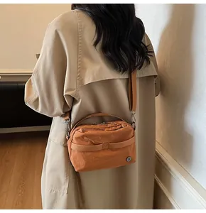 Detailed back view of a caramel nylon crossbody bag with an adjustable wide shoulder strap
