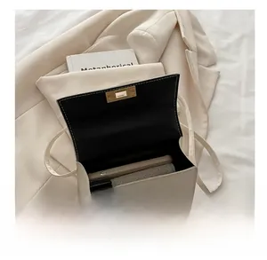 Détail intérieur d'un sac bandoulière beige montrant l'espace de rangement et le mobile