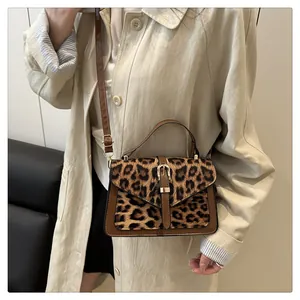 Detailed close-up of leopard print faux fur texture and gold buckle on a brown leather bag