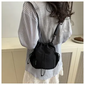 Detailansicht der schwarzen Beuteltasche mit Kordelzug, Netztaschen und Mode-Etikett
