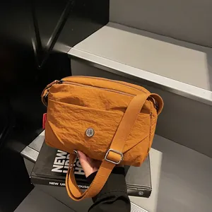 Minimalistische gelbe Umhängetasche aus Nylon mit breitem Gurt und mehreren Taschen
