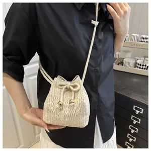 Dettaglio mini borsa a secchiello in paglia intrecciata con coulisse e tracolla