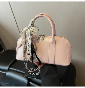Bolso Boston de cuero brillante rosa con lazo de encaje blanco y cadena de cuentas