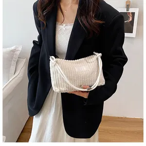 White corduroy tote bag shown on shoulder with minimalist indoor lifestyle background