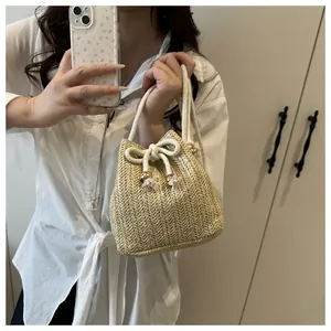 Dettaglio del secchiello intrecciato beige con coulisse e decorazione in perle metalliche
