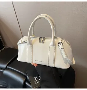 Detalle de bolso Boston en cuero blanco brillante con cremalleras plateadas