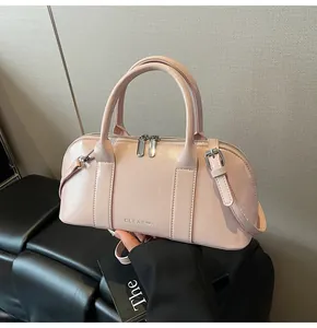 Primer plano del bolso Boston rosa claro con doble cremallera plateada y logo de CLEA❤K