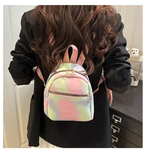 Detail of colorful tie-dye mini backpack with unique golden flower zipper pulls and leather straps